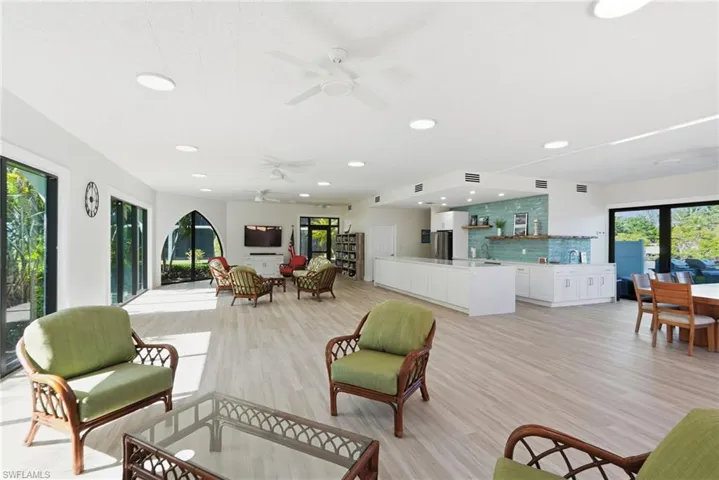 Clubhouse featuring a dining table, furniture, and a kitchen with a refrigerator and a microwave.