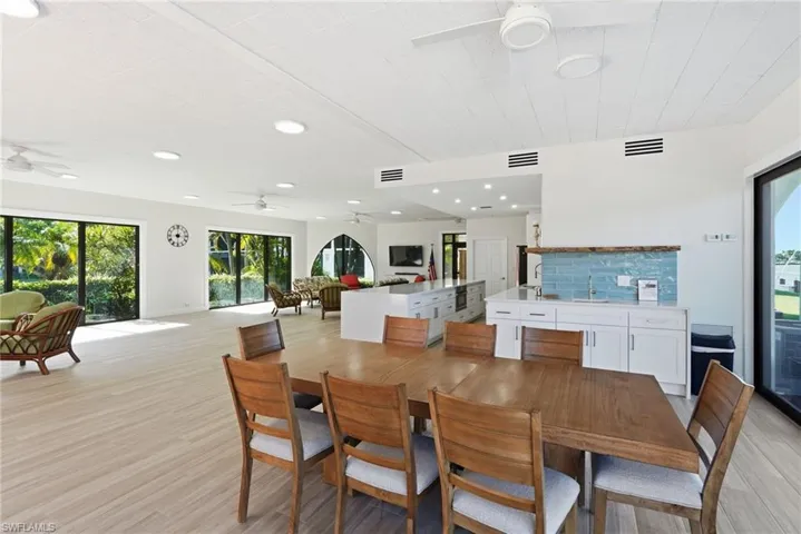 Clubhouse featuring a dining table, furniture, and a kitchen with a refrigerator and a microwave.