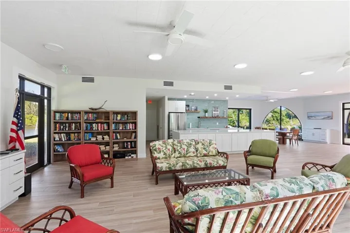 Clubhouse featuring a dining table, furniture, and a kitchen with a refrigerator and a microwave.