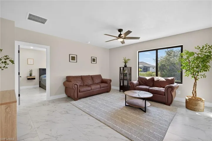 Living room with light marble finish flooring and ceiling fan