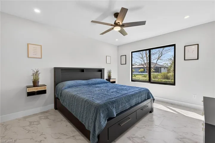 Bedroom featuring light marble finish floors, ceiling fan, and recessed lighting