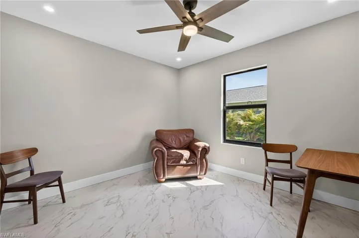 Living area with light marble finish flooring, recessed lighting, and a ceiling fan