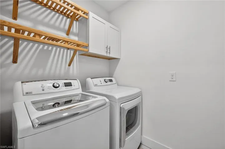 Laundry room featuring cabinet space and washer and clothes dryer