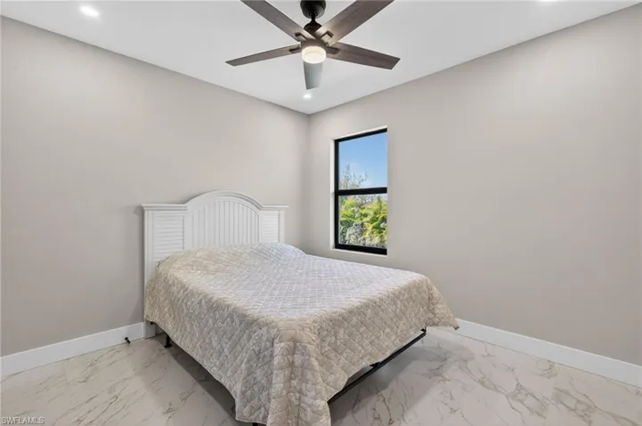 Bedroom featuring recessed lighting, a ceiling fan, and light marble finish flooring