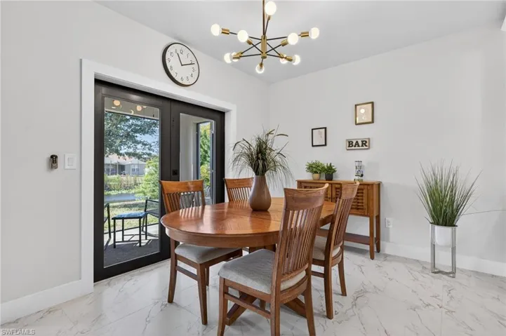 Dining area with hanging lights and light marble finish floors