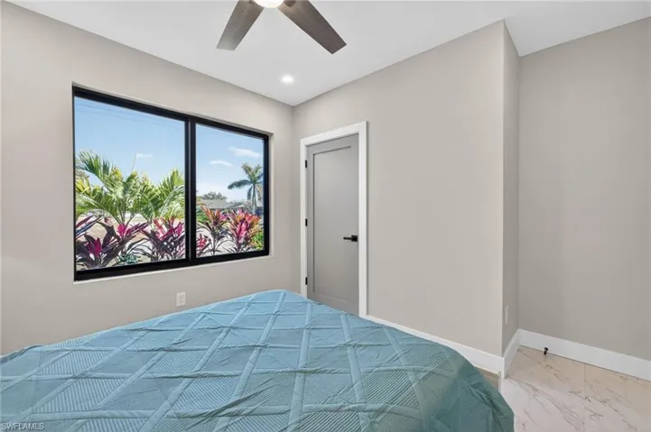 Bedroom featuring ceiling fan, light marble finish floors, and recessed lighting