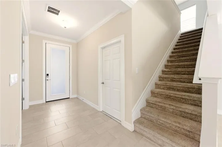 Entrance foyer with stairs and crown molding