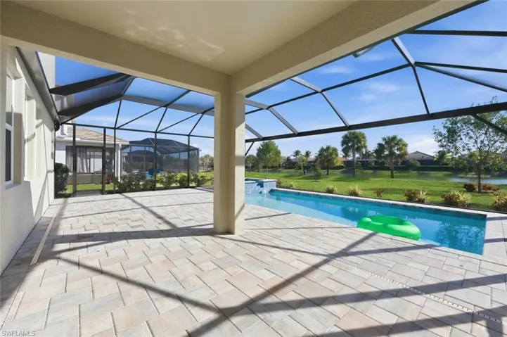 Integrated pool / spa featuring a sunroom, a patio, glass enclosure, and a yard