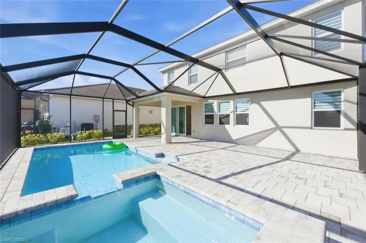 Relaxing pool / spa with a sunroom, a patio area, and a lanai