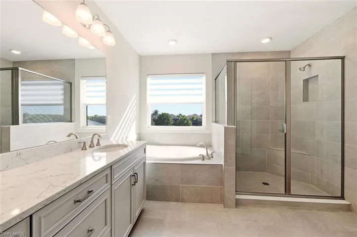 Bathroom with vanity, a stall shower, a garden tub, and recessed lighting