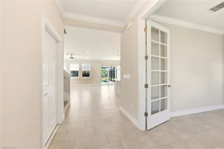 Hall featuring crown molding and light tile patterned floors