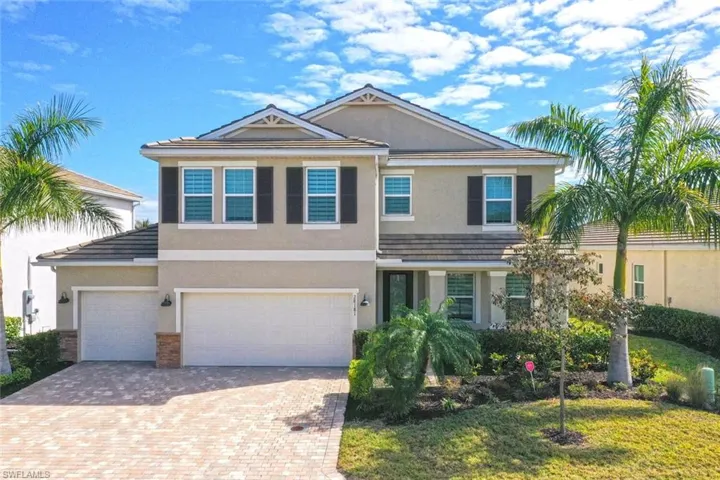 Traditional-style home with stucco siding, driveway, and a garage