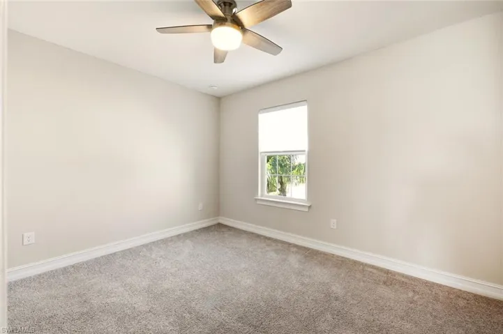Spare room featuring carpet and a ceiling fan