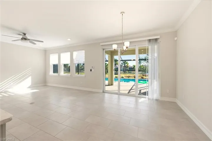 Unfurnished room featuring a chandelier, ceiling fan, crown molding, and light tile patterned floors