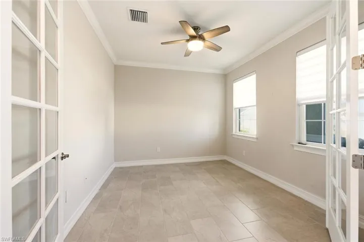 Spare room with ornamental molding, ceiling fan, and french doors
