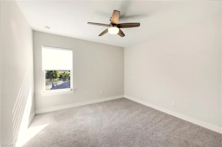 Unfurnished room with light carpet and a ceiling fan