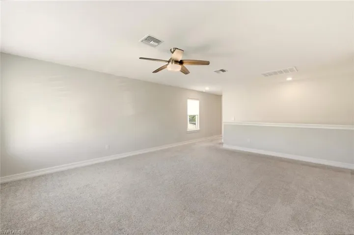 Empty room with carpet floors and a ceiling fan