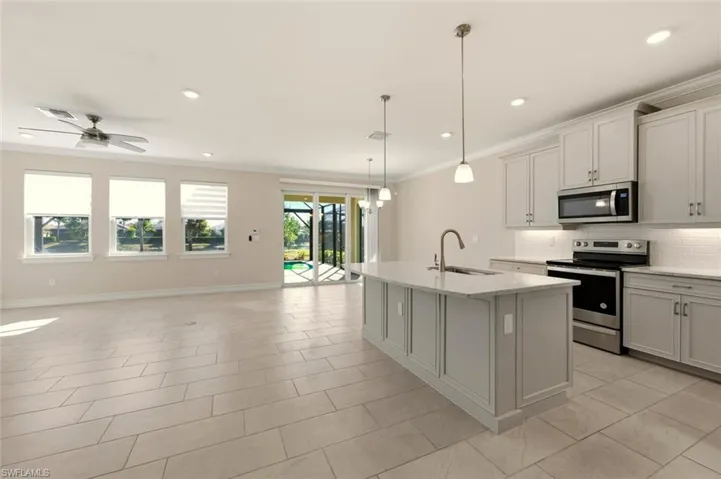 Kitchen with stainless steel appliances, crown molding, tasteful backsplash, a chandelier, and light stone counters