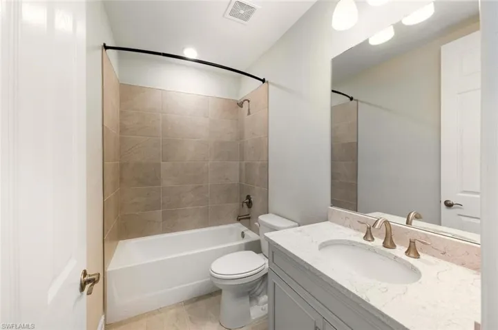 Full bathroom with vanity, bathtub / shower combination, and light tile patterned floors