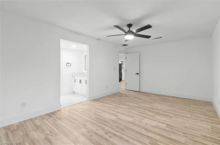 Unfurnished bedroom with light wood-style floors, a ceiling fan, and connected bathroom