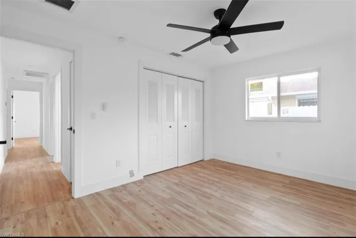 Unfurnished bedroom with light wood-style flooring, a closet, and ceiling fan