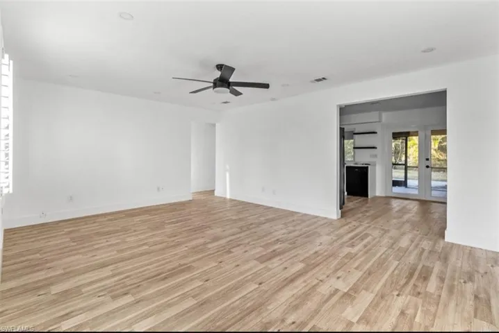 Unfurnished living room featuring light wood-style flooring, french doors, and ceiling fan