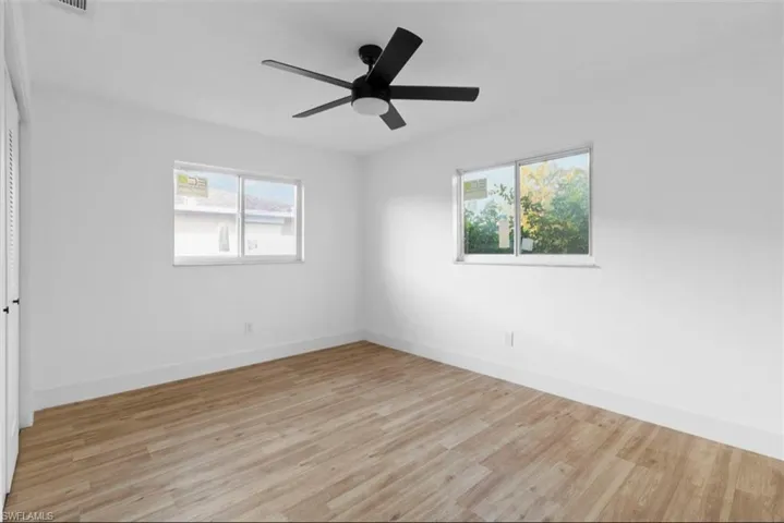 Empty room with light wood-style flooring and ceiling fan