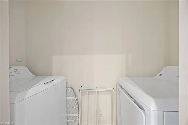 Washroom with washing machine and clothes dryer and laundry area
