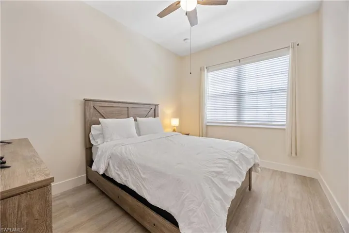 Bedroom featuring baseboards, a ceiling fan, and wood finished floors