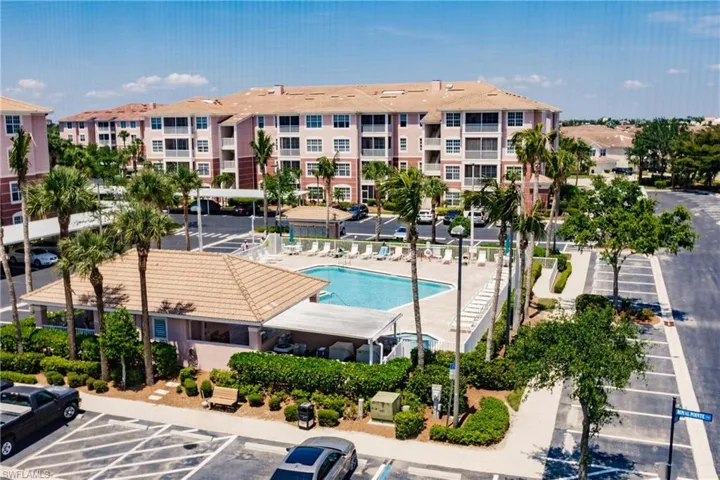View of property with uncovered parking and a community pool