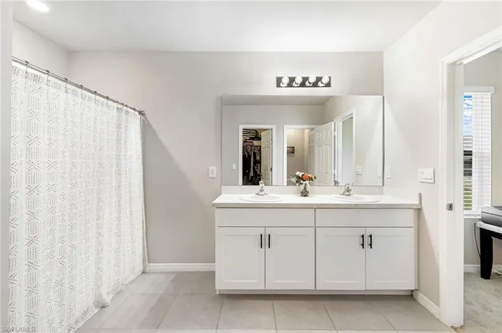 Bathroom featuring tile patterned floors, vanity, and a healthy amount of sunlight