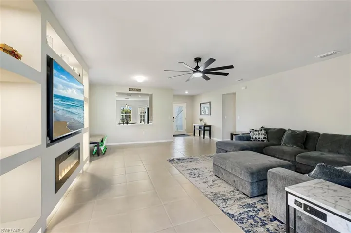 Living room featuring light tile patterned floors and ceiling fan