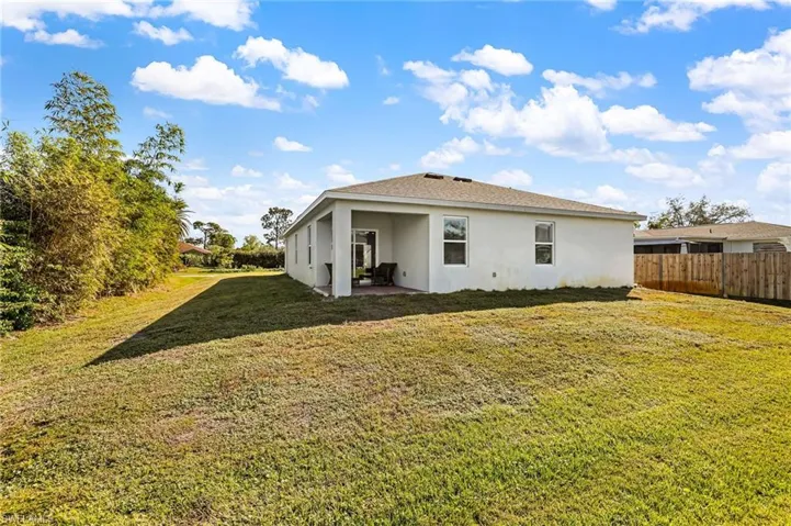 Rear view of property featuring a yard and a patio