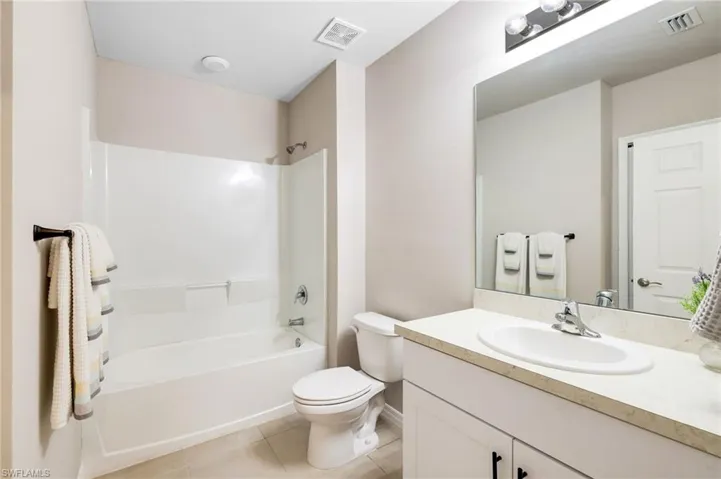 Full bathroom featuring tile patterned flooring, vanity, toilet, and bathtub / shower combination