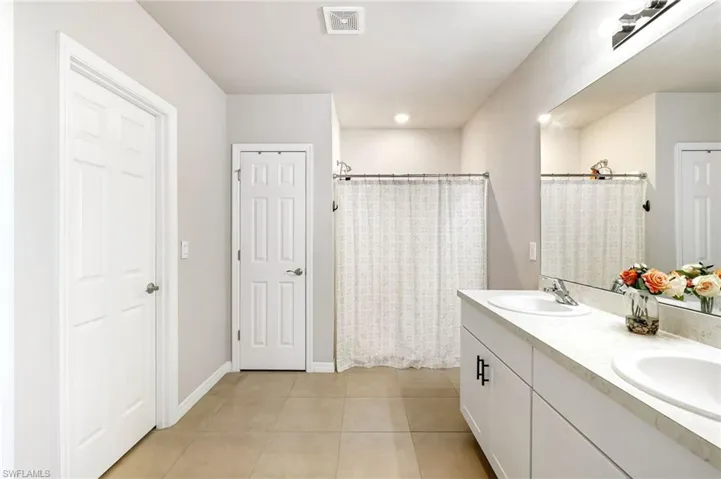 Bathroom with vanity, tile patterned floors, and walk in shower