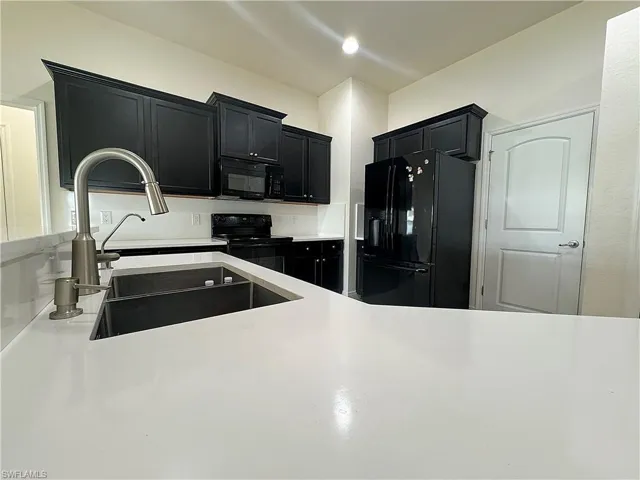 Kitchen featuring black appliances and sink