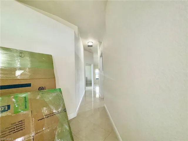 Hallway featuring light tile patterned flooring