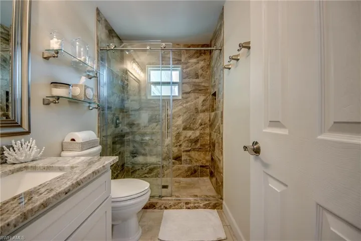 Full bathroom featuring vanity, a stall shower, and tile patterned flooring