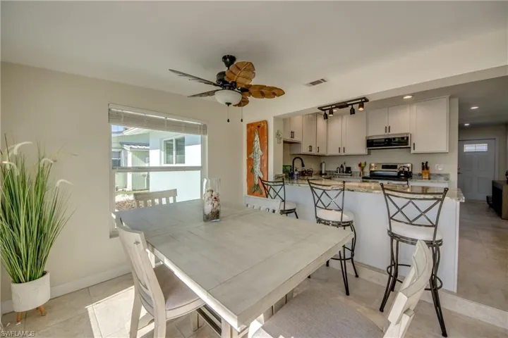 Dining space with a ceiling fan and light tile patterned flooring
