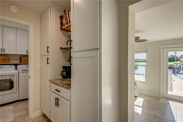 Washroom with washer and dryer, cabinet space, and light tile patterned floors
