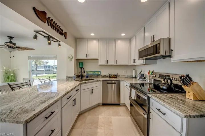 Kitchen with stainless steel appliances, recessed lighting, and white cabinets