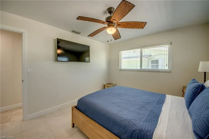 Bedroom with a ceiling fan and light tile patterned floors
