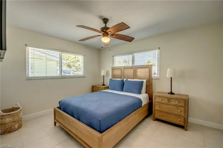 Bedroom featuring multiple windows, ceiling fan, and light tile patterned floors