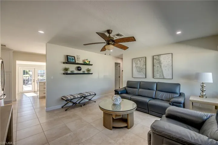 Living area featuring a ceiling fan, recessed lighting, and light tile patterned flooring