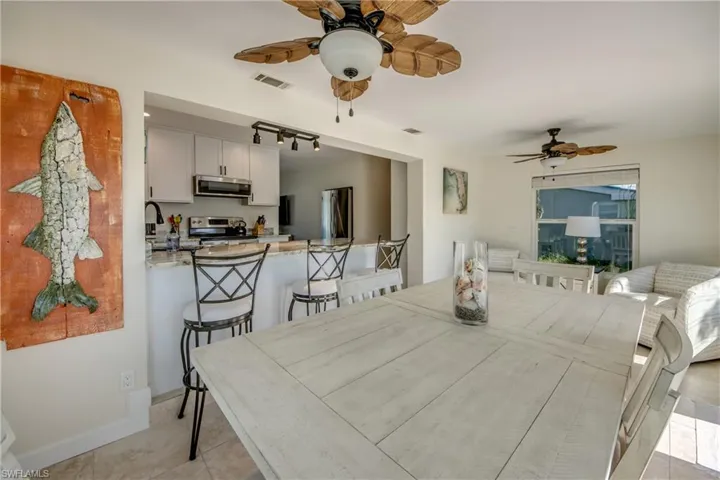 Dining room featuring a ceiling fan, rail lighting, and light tile patterned floors