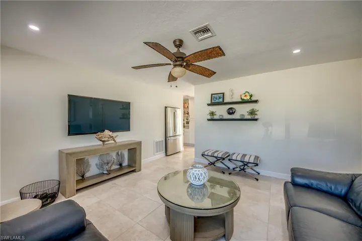 Living room featuring ceiling fan, recessed lighting, and light tile patterned floors