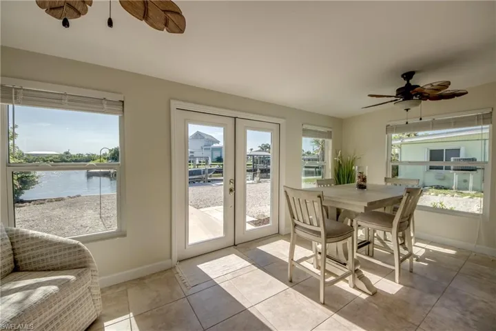 Sunroom / solarium featuring french doors and a water view