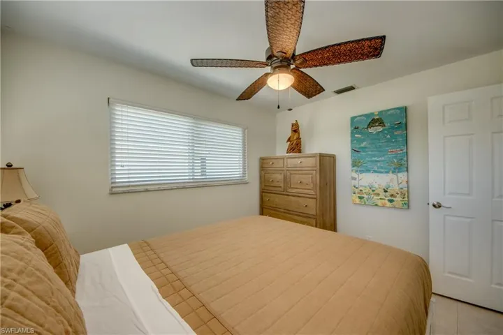Bedroom with light tile patterned flooring and ceiling fan