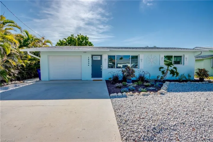 Single story home featuring a garage, concrete driveway, and stucco siding