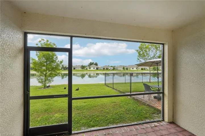 Unfurnished sunroom featuring a water view and a residential view